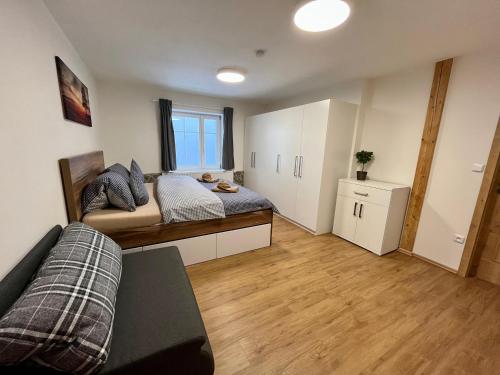 a bedroom with a bed and a couch in it at Chata Hubertka Krkonoše in Vítkovice