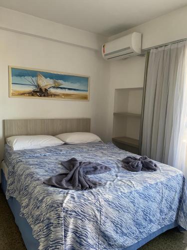 Un dormitorio con una cama con una manta. en Scala Residence particular, en Fortaleza