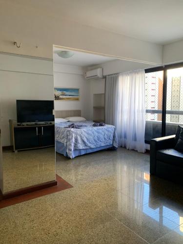1 dormitorio con cama y espejo en Scala Residence particular, en Fortaleza