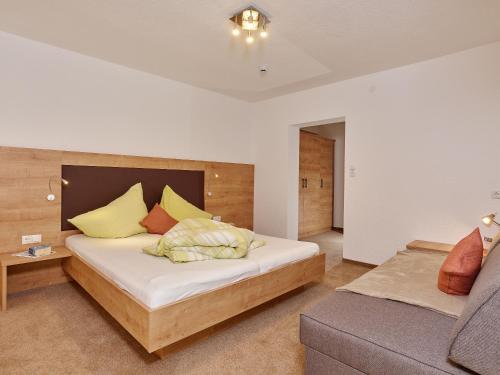 a bedroom with a bed and a couch at Fremdenpension Alpenruhe in Sölden