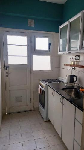 eine Küche mit einer weißen Tür und einem Herd Top-Backofen in der Unterkunft Lo de Juan in Mar del Plata