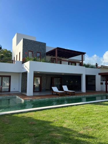 ein Haus mit einem Pool neben einem Hof in der Unterkunft Casa da Lua in São Miguel do Gostoso