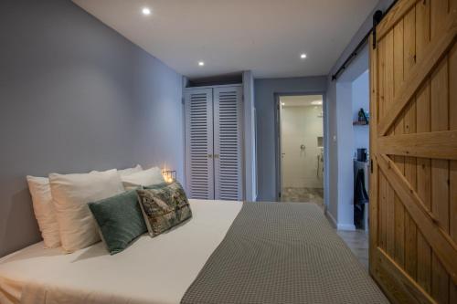 a bedroom with a large white bed with pillows at INDIGO Apartments & Suites - 'Adults Only' in Jan Thiel