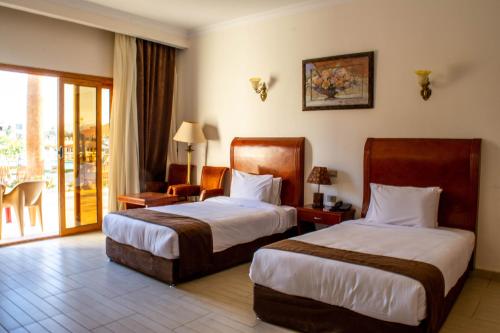 Palma Di Sharm Hollywood Resort في شرم الشيخ: غرفة فندقية بسريرين وبلكونة