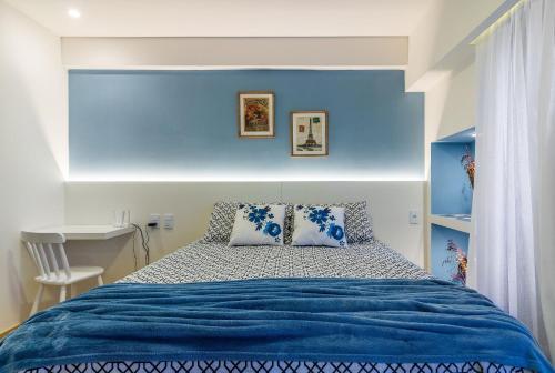 1 dormitorio con 1 cama con pared azul en Apartamento Lindo e Aconchegante - Av. Beira Mar, en Fortaleza
