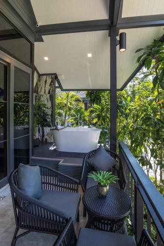 a screened porch with chairs and a bath tub at Loy Chalet in Klong Muang Beach
