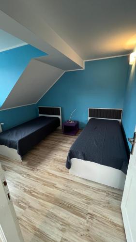 a bedroom with a bed and blue walls and wooden floors at Charlie&Blueberries in Belgrade