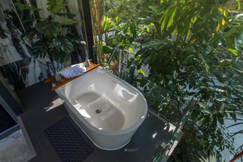 a white sink in a garden with plants at Loy Chalet in Klong Muang Beach