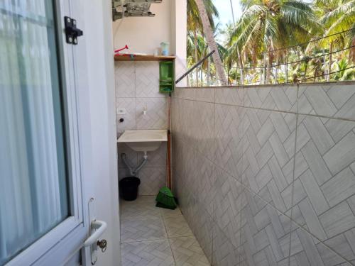 a bathroom with a shower with a sink and a window at Pousada Beach Claudia in Maragogi