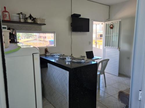a kitchen with a black counter top and a table at Pousada Beach Claudia in Maragogi