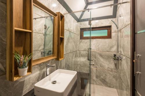 y baño con lavabo y ducha acristalada. en Loy Chalet en Klong Muang Beach