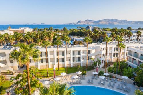 an aerial view of a hotel with a pool and palm trees at Apollon Hotel in Kos