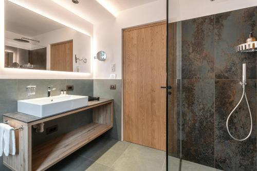 a bathroom with a sink and a shower at Alpenrose Alpine Living in Selva