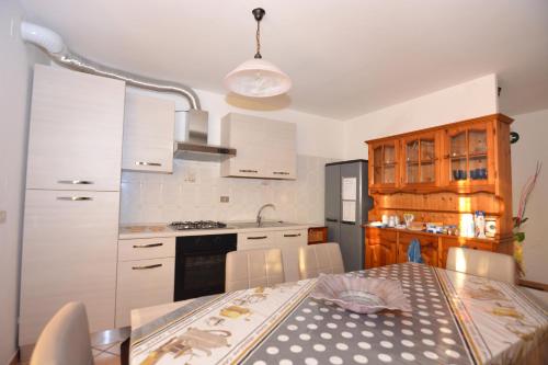 Short-lets affittacamere في Montemitro: مطبخ مع طاولة ومطبخ مع دواليب بيضاء