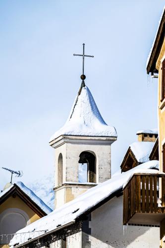 a church steeple with a cross on top of it at Appartement spacieux à Briançon 86 m² avec vue montagne in Briançon