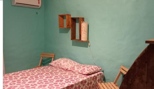 a bedroom with a bed with a pink comforter at Casinhas Vila Bonita Marajás in Baía Formosa