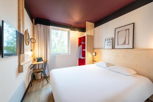 una camera con un letto bianco e due finestre di Greet hotel Bourg-en-Bresse Sud Montagnat a Montagnat