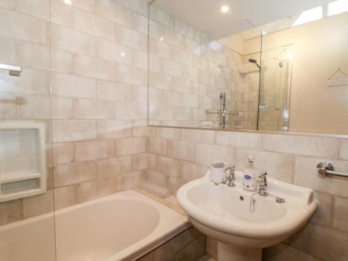 a bathroom with a sink and a toilet and a tub at 1 Little Ripple Cottages in Canterbury