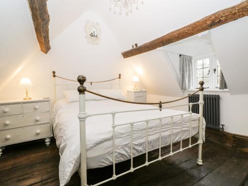a bedroom with a white bed and a dresser at Foxden in Sherborne
