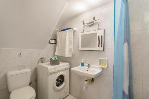 uma pequena casa de banho com uma máquina de lavar roupa e um lavatório em Traditional Home em Naousa