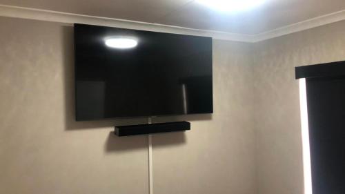 a flat screen tv hanging on a wall at St Pete Private Suites in Newton Park