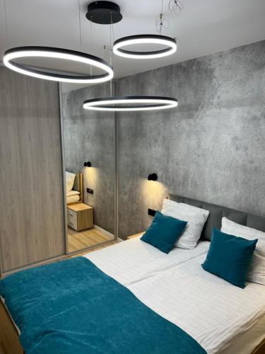 コウォブジェクにあるSolna Apartament PREMIUMのベッドルーム(青い枕の大型ベッド1台付)