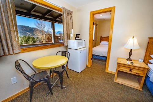 um quarto com uma mesa e cadeiras e uma janela em Coyote Mountain Lodge em Estes Park