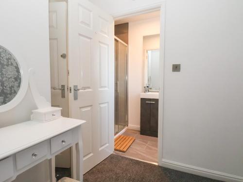 a bathroom with a shower and a white door at The Beach House in Prestatyn
