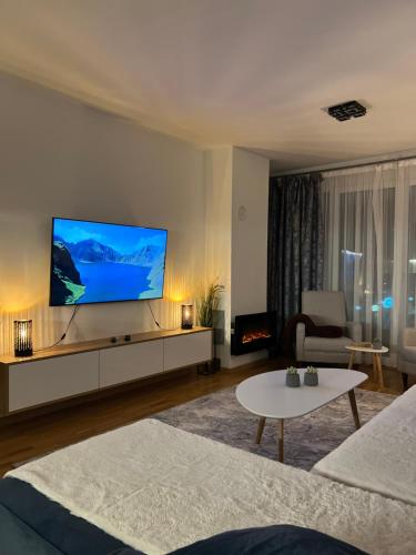 a living room with a large flat screen tv at Rest Apartman, Bjelašnica in Bjelašnica