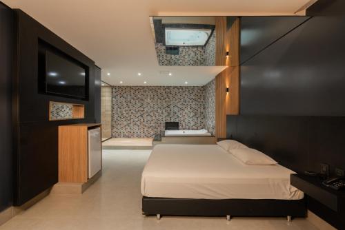 1 dormitorio con 1 cama y TV de pantalla plana en Drops Vale dos Sinos, en Ararica