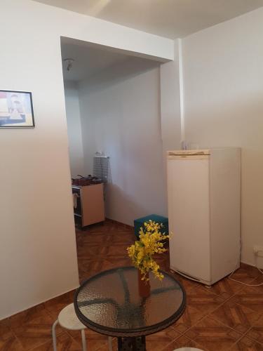 a room with a glass table and a refrigerator at Kitnet mobiliado centro in Nova Friburgo
