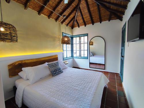 een slaapkamer met een bed in een kamer met een spiegel bij Trip Monkey Girón in Girón