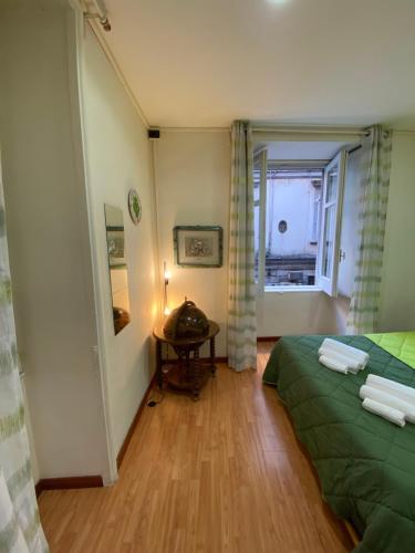 ナポリにあるAngy's Houseのベッド2台、テーブル、窓が備わる客室です。