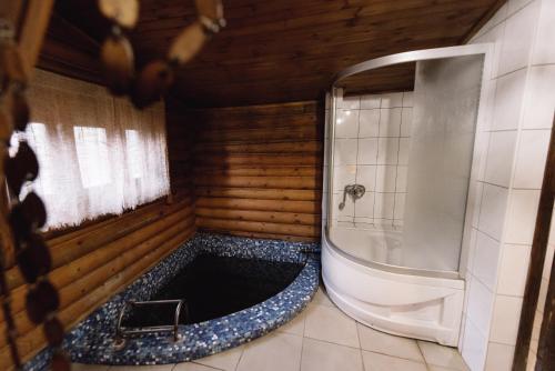 a bathroom with a shower and a tub with a toilet at Готель Яблуниця in Yablunytsya