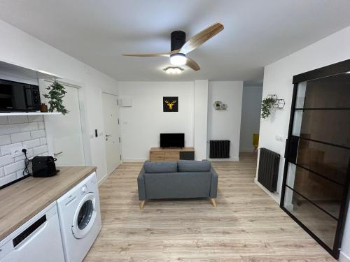 uma sala de estar com um sofá e uma ventoinha de tecto em Industrial -Apartamentos Birdie- em Albacete