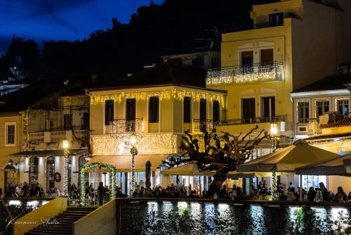 a group of people sitting outside of a building at night at Vip Lepanto Port Suites in Nafpaktos