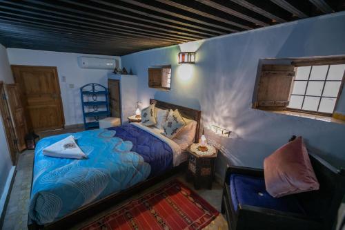 een blauwe slaapkamer met een bed en een raam bij Riad Dar Hidaya Fes in Fès