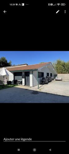 a white building with a red roof and a table at Maison au Haillan in Le Haillan