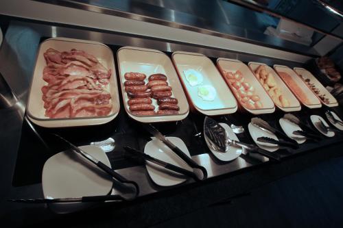a stove with trays of food on top of it at Ramada Oxford in Waterstock