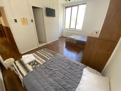 a bedroom with a bed in a room with a window at Hostal Ochen in Punta Arenas