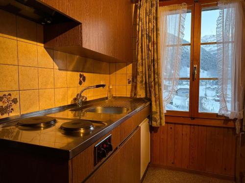 cocina con fregadero y ventana en Hotel Bären Lodge, en Kiental
