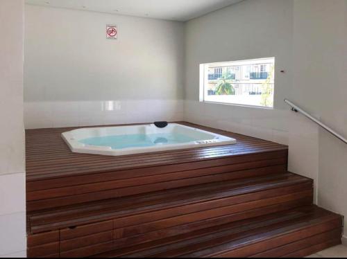 a jacuzzi tub in a room with a window at Flat Completo Granja Brasil in Petrópolis