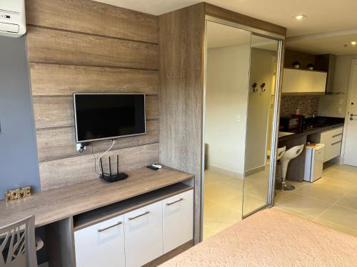 a living room with a flat screen tv on a wall at Flat Completo Granja Brasil in Petrópolis