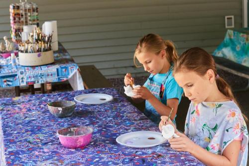 dos chicas sentadas en una mesa comiendo comida en Moody Beach Camping Resort Loft Park Model 14, en Moody