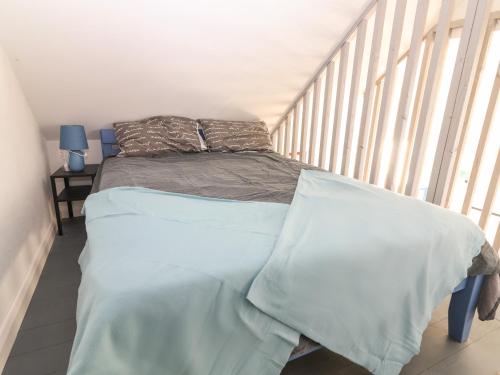 a bedroom with a bed with blue sheets at Mountain View in Kinvara