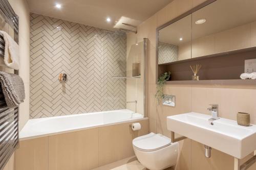 a bathroom with a sink and a tub and a toilet at Luxury 2 bedroom apartment with free parking in the heart of York in York