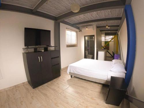 een slaapkamer met een bed en een flatscreen-tv bij Apartamento 3 Cali Sur in Cali