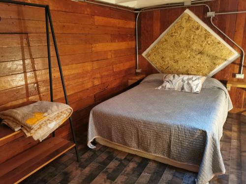 sypialnia z łóżkiem w drewnianej ścianie w obiekcie Loft Histórico Manuel Rodriguez w mieście Iquique