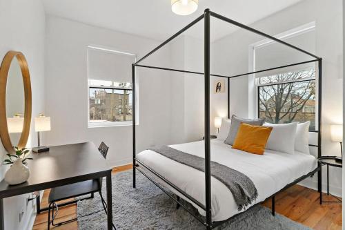 1 dormitorio con cama, escritorio y espejo en Contemporary 4BR Apt close to Restaurants - Racine 202, en Chicago