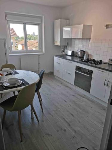 - une cuisine avec une table, une table et des chaises dans l'établissement Charmant appartement au calme, à Bourg-en-Bresse